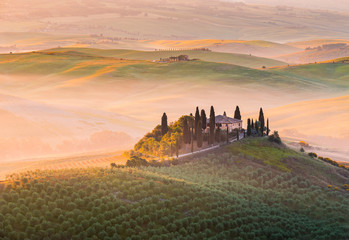 Obraz premium A lonely farmhouse between tuscan rolling hills. Val d'Orcia, Siena province, Tuscany, Italy