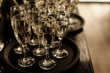 luxury glasses with  champagne on stylish decorated table at wedding reception. expensive catering at restaurant for celebrations. transparent glass and space for text. alcohol bar