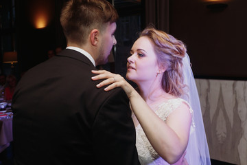 Newlywed couple first dance at ballroom, bride and groom dancing at wedding reception in restaurant, happy handsome husband and beautiful wife moment