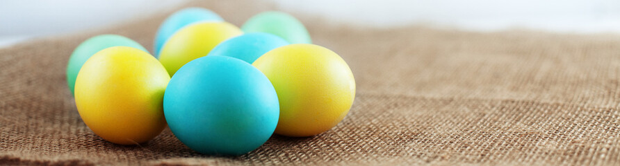Colored eggs lying on the sacking. The concept of a happy Easter