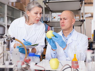 Scientists taking notes while performing experiments