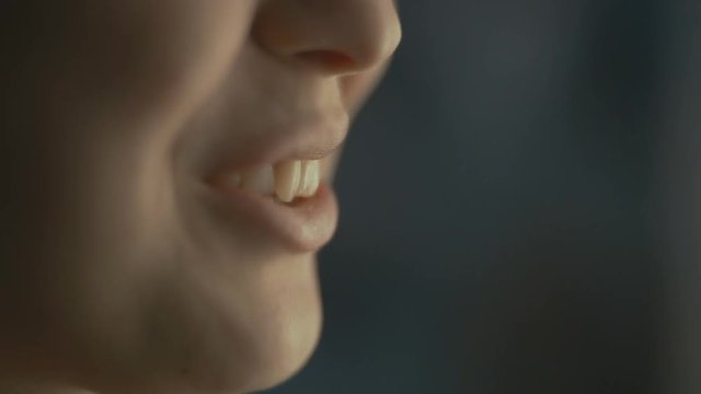 lips young woman talks at home with a friend at the window, part of the face is a girl smiling, concept of health and friendship
