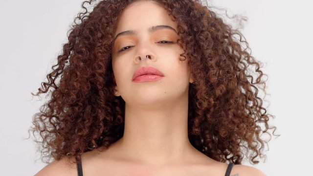 slow motion from 60 fps hair blowing closeup portrait of mixed race model with freckles slightly smiling