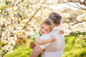 Gentle embrace of father and son in the park. Masculinity concept. Family love