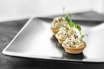 Delicious snack with chicken and cheese in tartlets. Concept of food, restaurant, catering, menu.