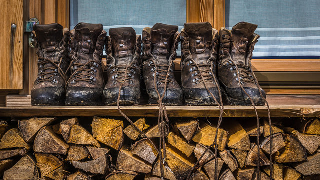 Drei Paar Wanderschuhe zum Trocknen auf Holzstapel aufgestellt