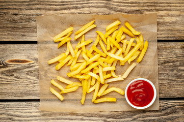 French fries with ketchup on wooden background
