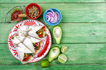 Burritos wraps with beef and vegetables on wooden background. Beef burrito, Mexican cuisine. Top view
