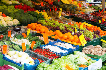 Sale of vegetables and fruits in the market. On the plates are written the names of vegetables in German