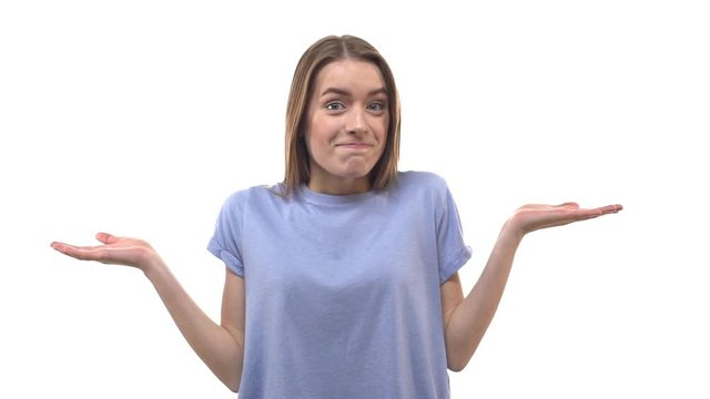 Slowmo lovely blond 20s woman smiling raising hands sideways shrugging unaware giving sorry grin, shaking head no gesture, uncertain, not know anything, cannot help, puzzled answer, white background