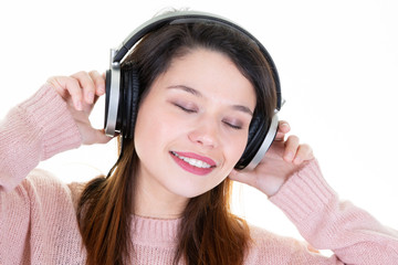 Happy woman enjoying listening to the music from headphones closed eyes