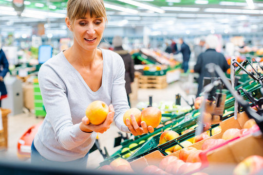 Frau testet das frische Obst im Supermarkt Regal 