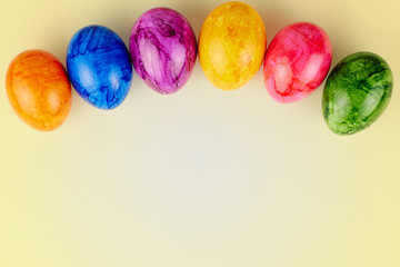 Colored Easter eggs on yellow background.