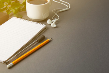 Desk workspace, grey workspace with cup of coffee, empty notebook and plant on dark table. Cup of coffee and space for text. flat lay. Copy space.
