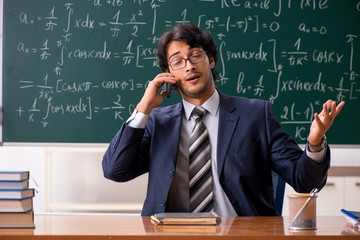Young male math teacher in classroom 