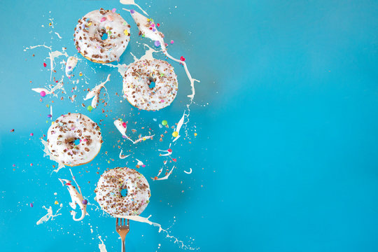 Floating in the air donuts on a blue background. Sweets, pastries.