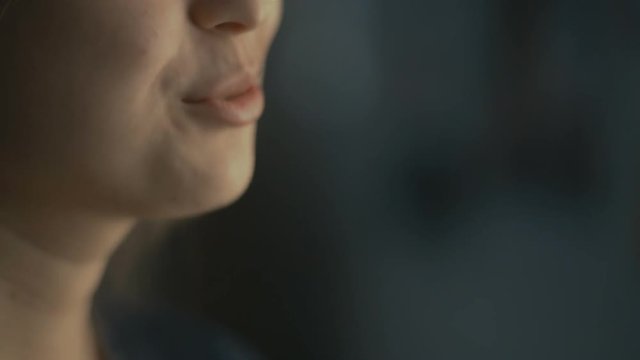 lips young woman talks at home with a friend at the window, part of the face is a girl smiling, concept of health and friendship