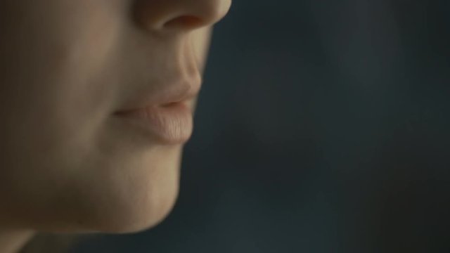 lips young woman talks at home with a friend at the window, part of the face is a girl smiling, concept of health and friendship