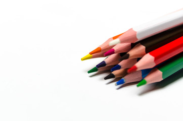 Colourful sharp pencils lie on a white background