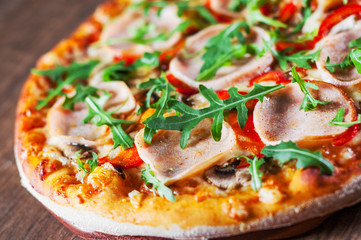 Pizza with Mozzarella cheese, mushrooms, ham, tomato sauce, pepper, Spices and Fresh arugula. Italian pizza on wooden table background 