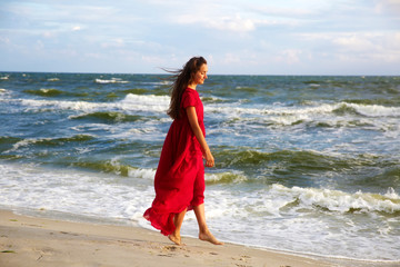 Woman in red on the sea coast