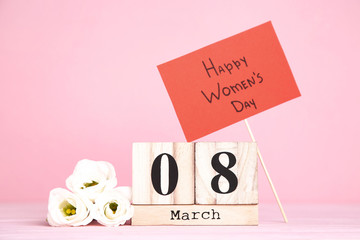Wooden calendar with eustoma flowers and text Happy Women's Day
