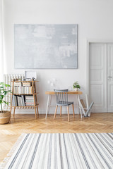 Stylish scandinavian home decor of interior with creative wooden desk, bamboo bookstand with...