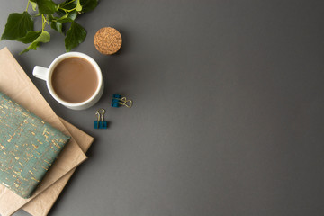 Styled office desk table with blank notebook, office supplies and coffee cup. Top view with copy space. Flat lay.