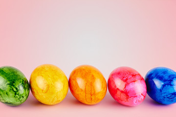 Fototapeta na wymiar Colored Easter eggs on pink background