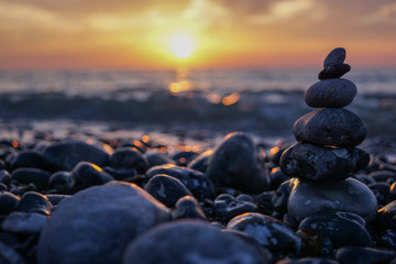 Sunset and stone sculpture pebble - Zen relaxation and harmony. Near Dieppe, France