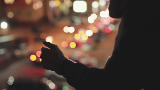 Silhouette of man in night city unblock his smarphone