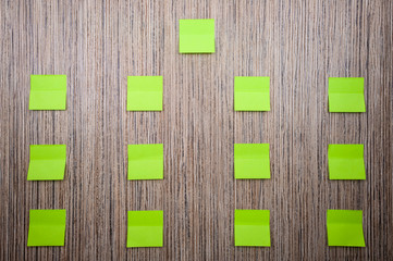 lot of green stickers for notes on a wooden background. Mockup for designer.