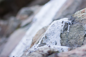 Icicles on granite rocks. Frozen water on stones. Clear water in winter. Freshwater source in mountains