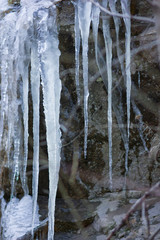 Icicles on granite rocks. Frozen water on stones. Clear water in winter. Freshwater source in mountains