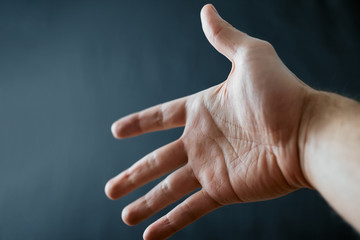 Adult hand with Raynaud's Syndrome - Phenomenon. Close up hand with fingers on dark background with copy space