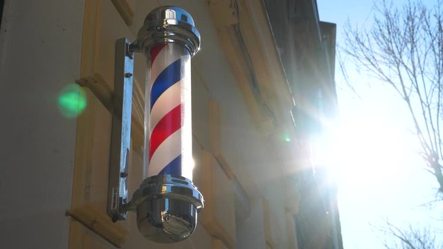 Historic old fashioned antique barber pole in a small town business barber shop. Barber shop vintage pole retro.