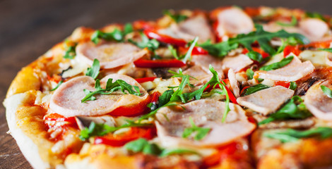 Pizza with Mozzarella cheese, mushrooms, ham, tomato sauce, pepper, Spices and Fresh arugula. Italian pizza on wooden table background