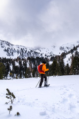 Man snowshoeing on Scheibelalm in Hohentauern with dark cloudy sky