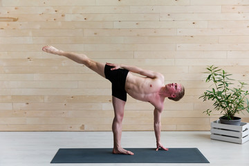 Sporty man practicing yoga on yoga class