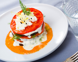 Fried eggplant pyramid with tomatoes on spicy sauce