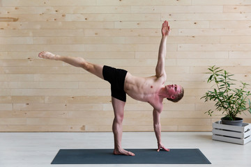Sporty man practicing yoga on yoga class