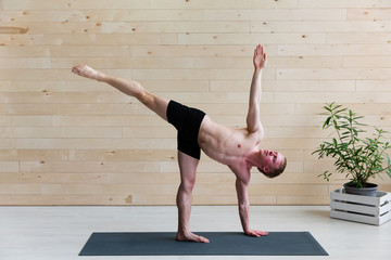 Sporty man practicing yoga on yoga class