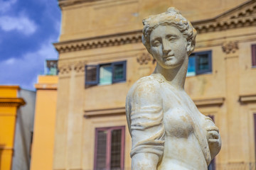 Fototapeta na wymiar Feminine white stone statue in a Palermo square