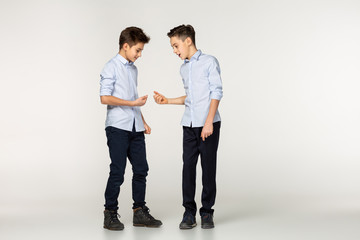 Two friends teenagers in blue shirts playing a game of stone, paper and scissors