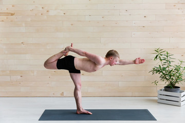 Sporty man practicing yoga on yoga class