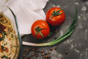 Chicken chop meat under cheese on a gray background tomatoes pepper tree