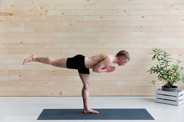 Sporty man practicing yoga on yoga class