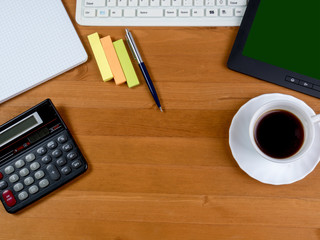 table with a cup of coffee, office accessories and electronic gadgets