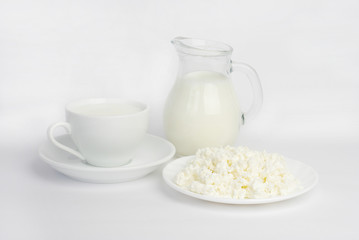 Cup of milk, jug of milk and cottage cheese on a white background