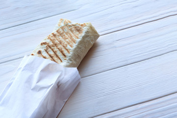 The girl's hair is white. eats shawarma. Fast food.
